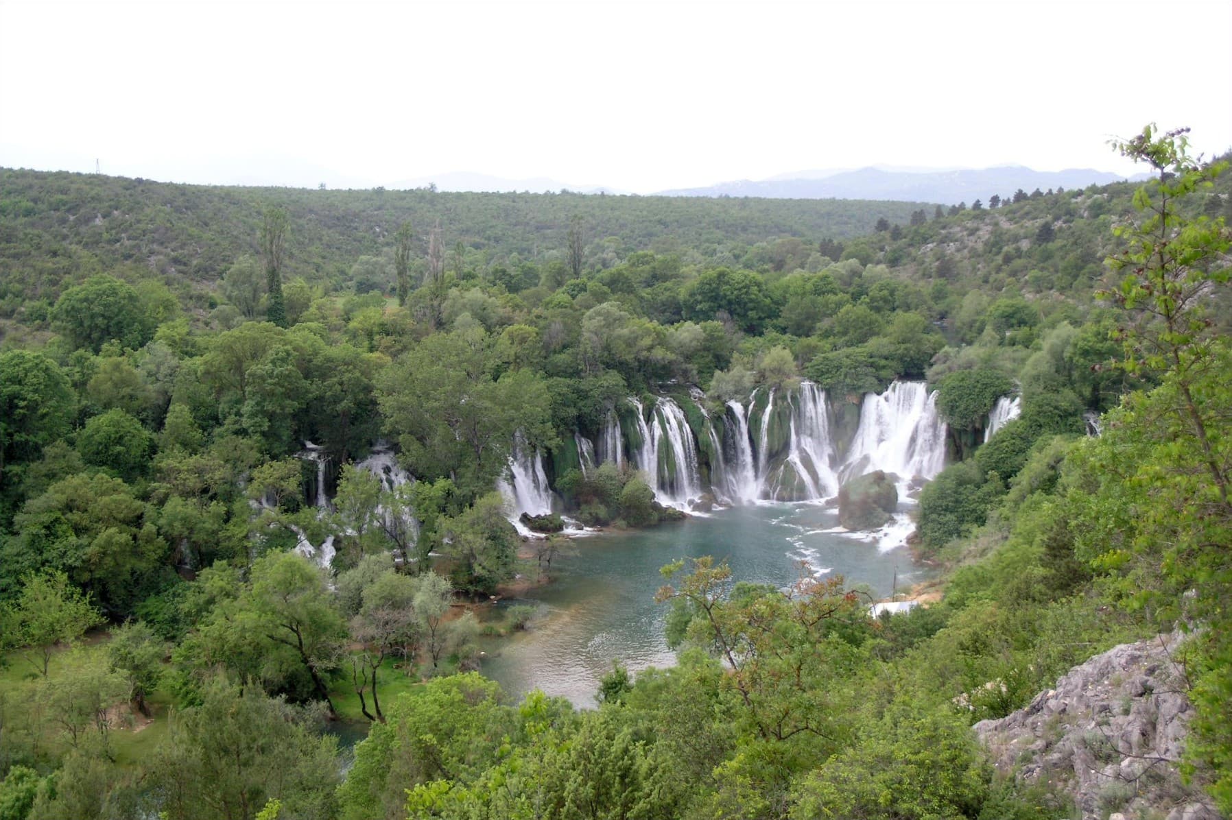 Kravica Waterfalls cascading into a wide travertine pool near Mostar